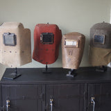 An unusual antique welder's mask on a stand