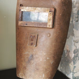An unusual antique welder's mask on a stand