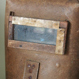 An unusual antique welder's mask on a stand