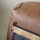 An unusual antique welder's mask on a stand