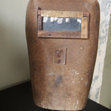 An unusual antique welder's mask on a stand