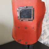 An unusual antique welder's mask on a stand