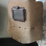An unusual antique welder's mask on a stand