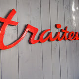 old zinc sign with the word "caterer" in bright red