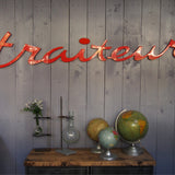 old zinc sign with the word "caterer" in bright red