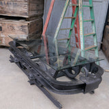 Industrial metal coffee table in the shape of a mine cart on rails with a glass top